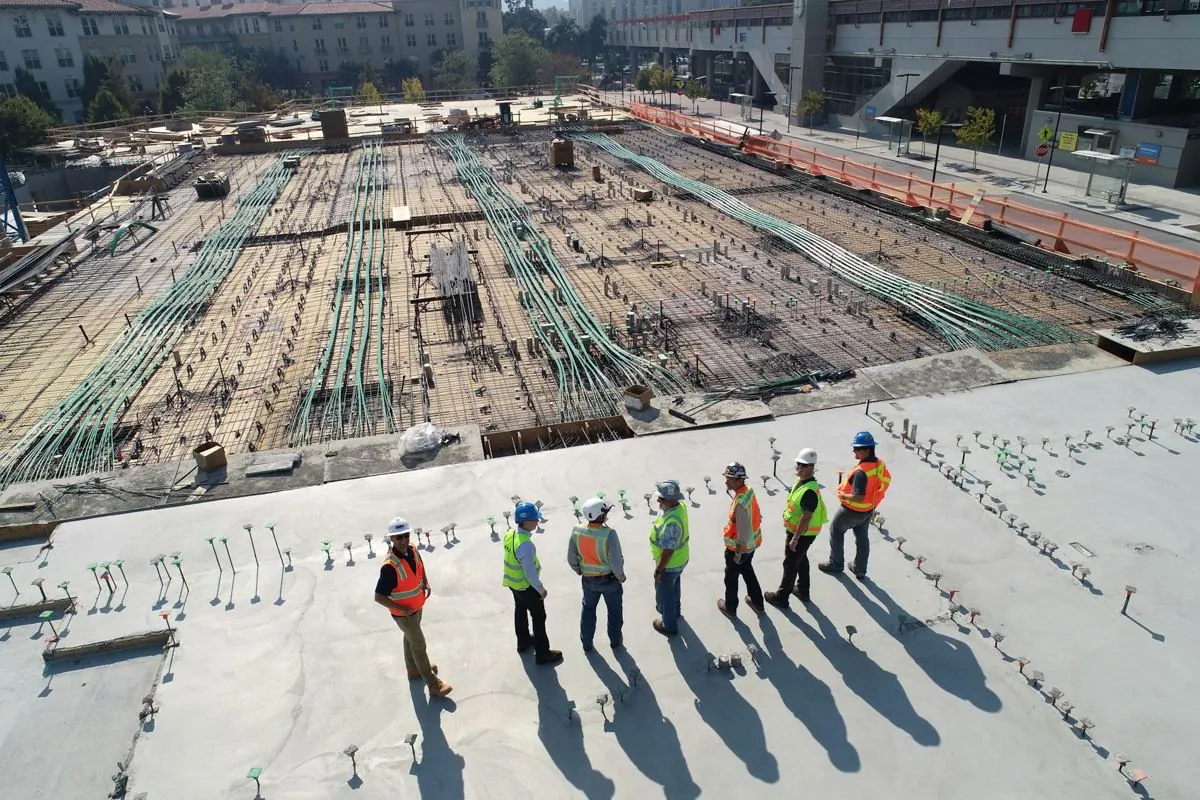 Vista aèria d'una obra amb la plataforma preparada i l'equip caminant-hi